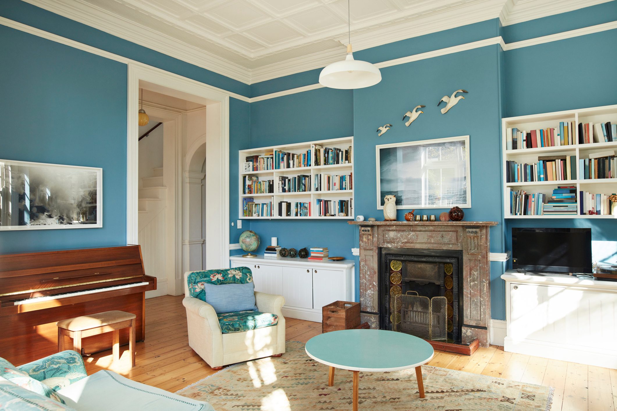 Fireplace and bookshelf with piano in living room at home