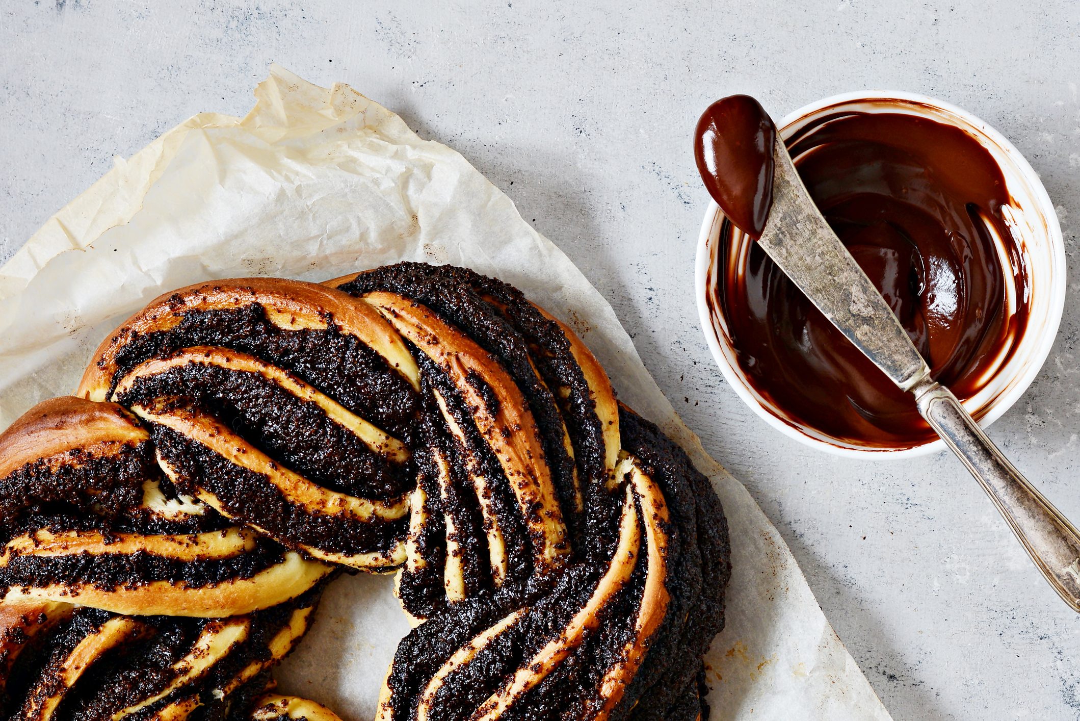 chocolate brioche Kringle in a twisted ring shape with a side of chocolate sauce