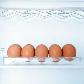 Somes eggs inside a cold and empty fridge