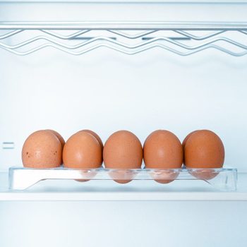 Somes eggs inside a cold and empty fridge