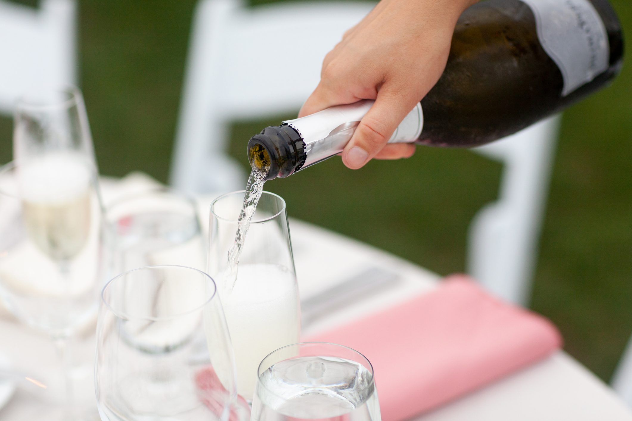 Champagne being poured into glasses at reception table