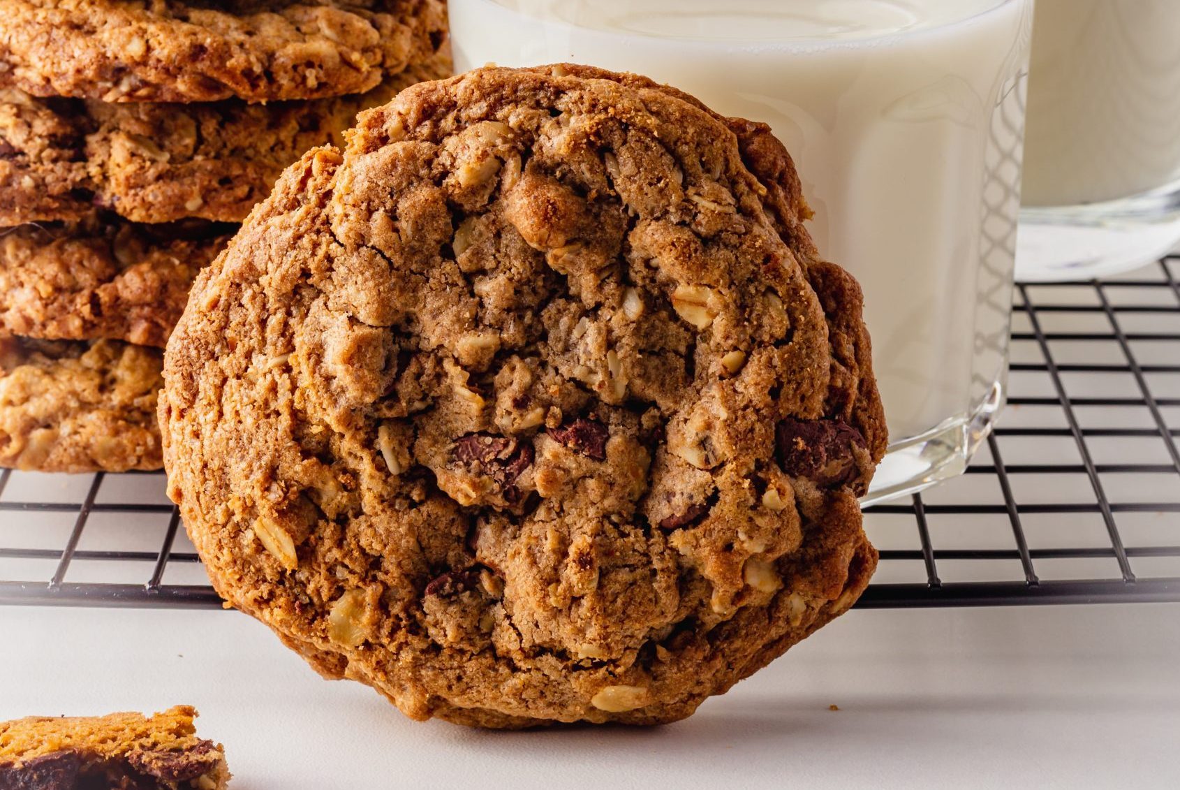 Homemade chocolate chip cowboy cookie on a wooden board and cooling rack