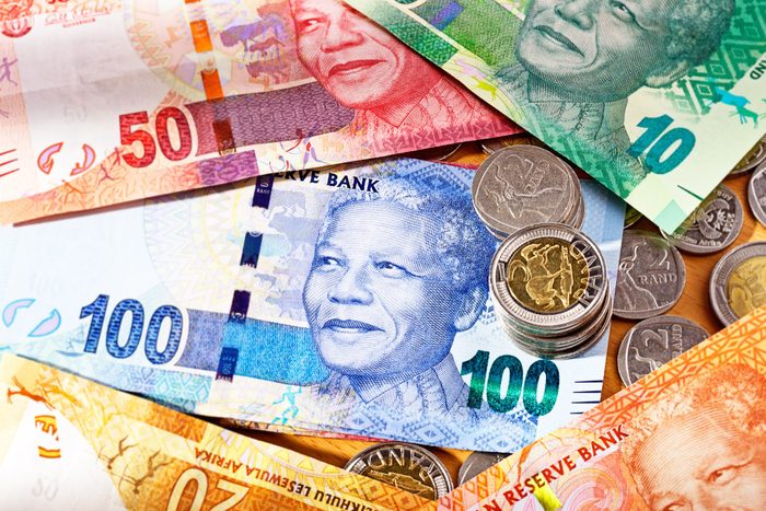 Varied new South African Mandela banknotes with coins