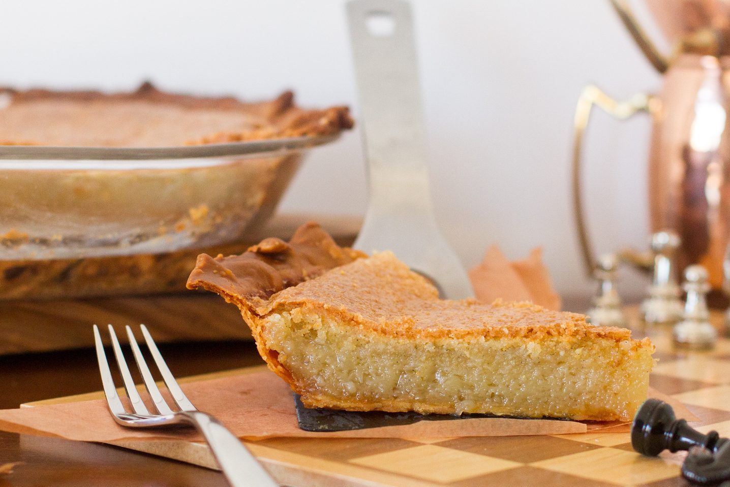 close up of a slice of chess pie on a chess board