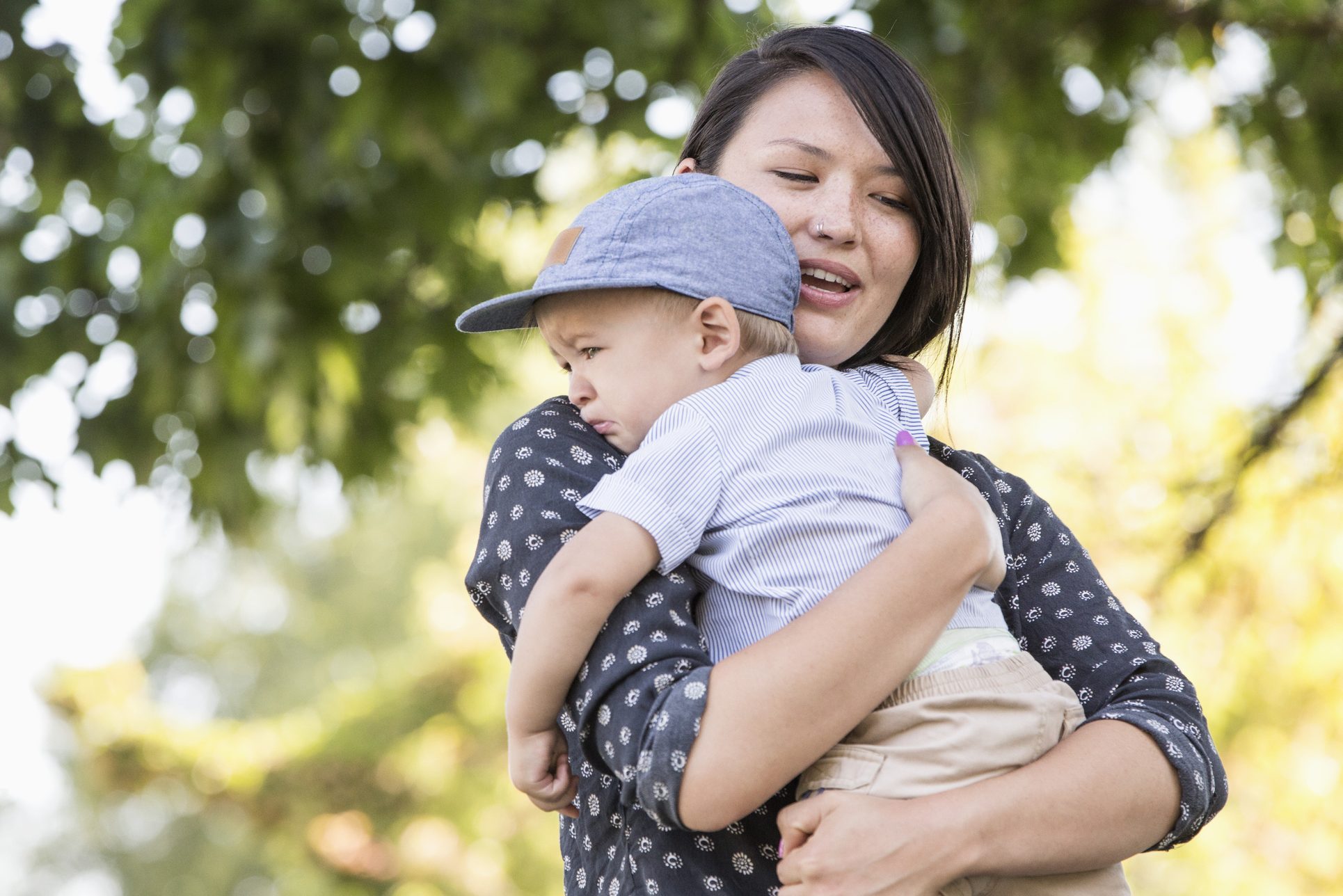 Mixed race mother comforting crying son outdoors