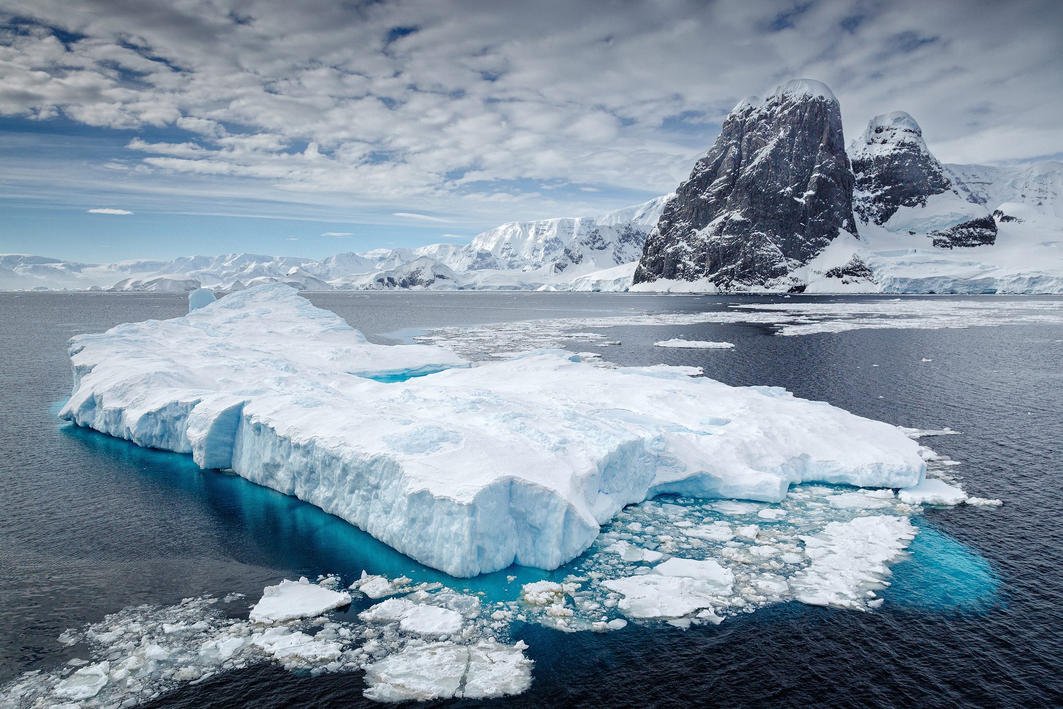 Clouds over iceberg floating on water, Antarctica