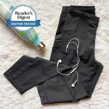 black leggings arranged with earbud headphones and a water bottle