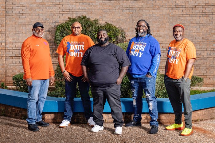 Five members of Dads on Duty standing in front of Southwood High School.