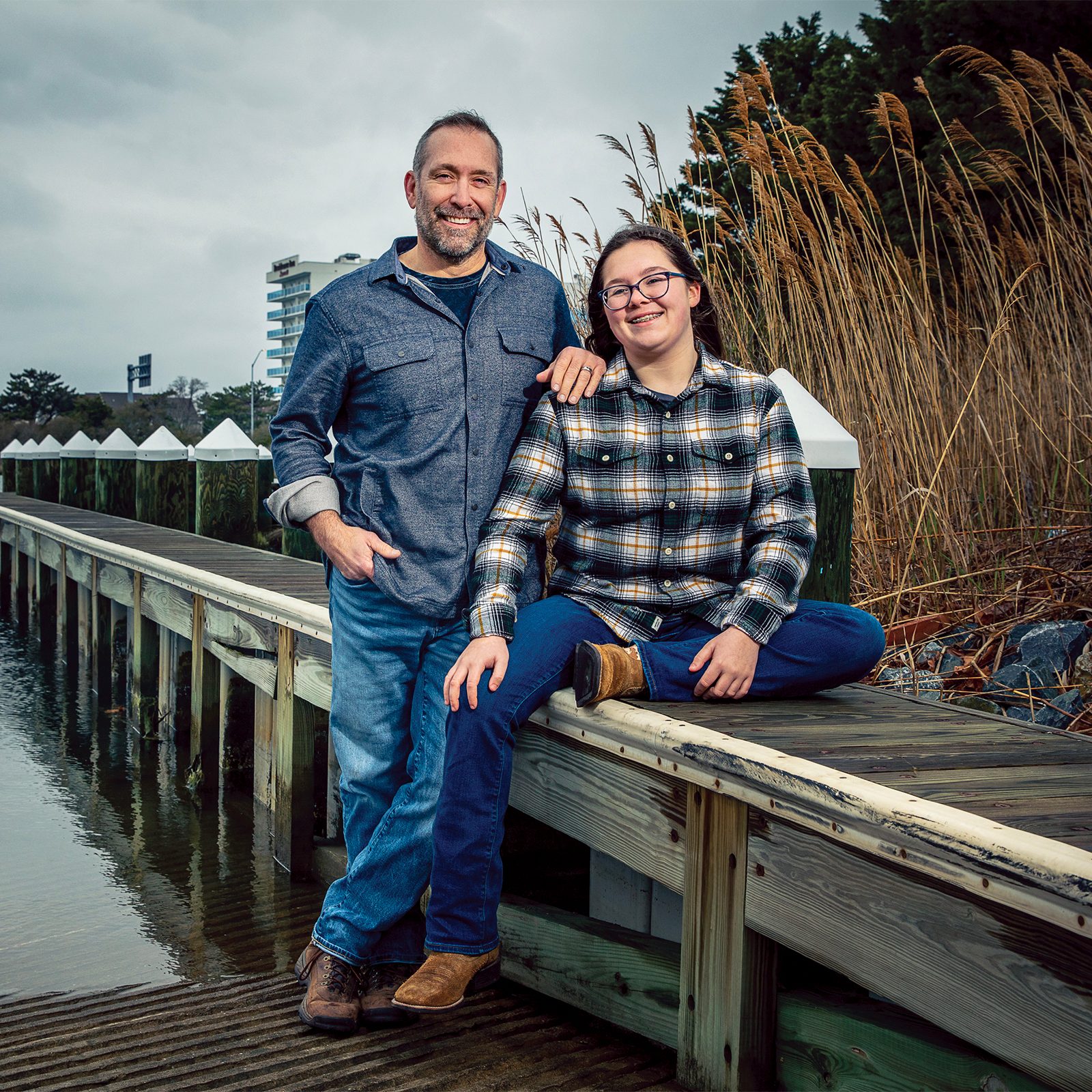 Man and daughter sitting on a pier