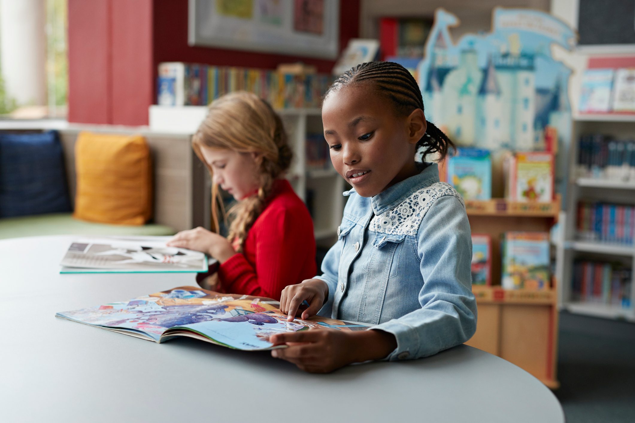 Schoolgirls reading books in school library