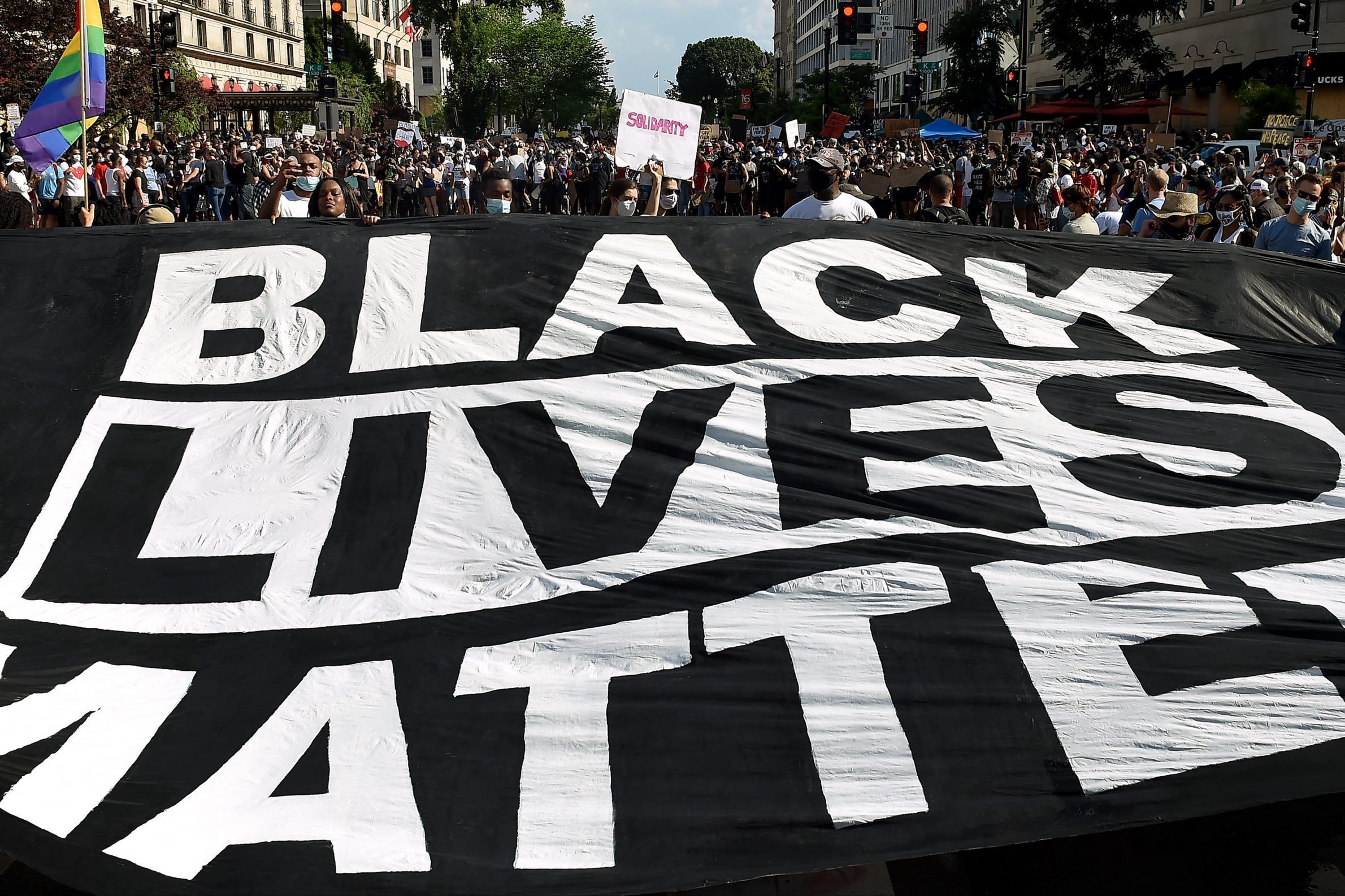 Demonstrators deploy a " Black Lives Matter" banner