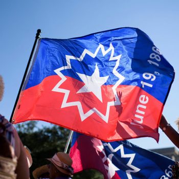 People carry a Juneteenth flag as they march during a Juneteenth re-enactment celebration in Galveston, Texas, on June 19, 2021.