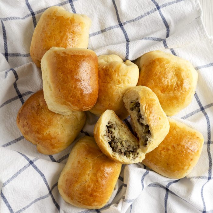 Home-baked Beef Russian Bierocks on a white wooden table, top view. Flat lay, overhead, from above.