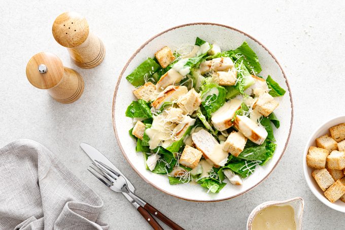 Caesar salad with parmesan cheese, grilled chicken meat and croutons