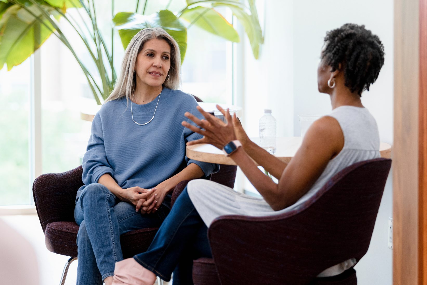 Diverse mature adult women meet at cafe to chat