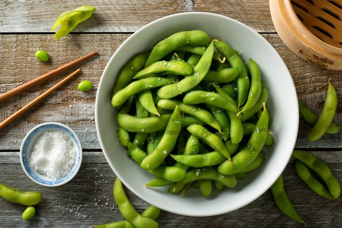 Fresh steamed edamame sprinkled with sea salt on a rustic tabletop