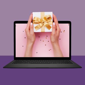 hand holding gift coming out of computer screen