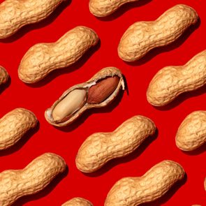 Repeated peanuts ad one halved nut on the red background