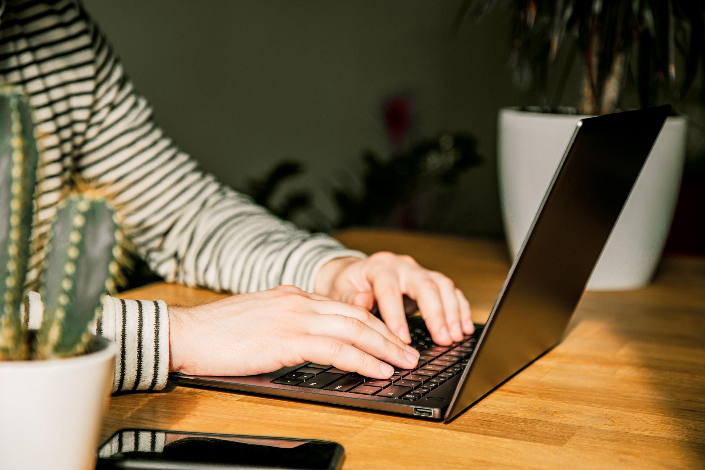 Close-up of man's hands using laptop