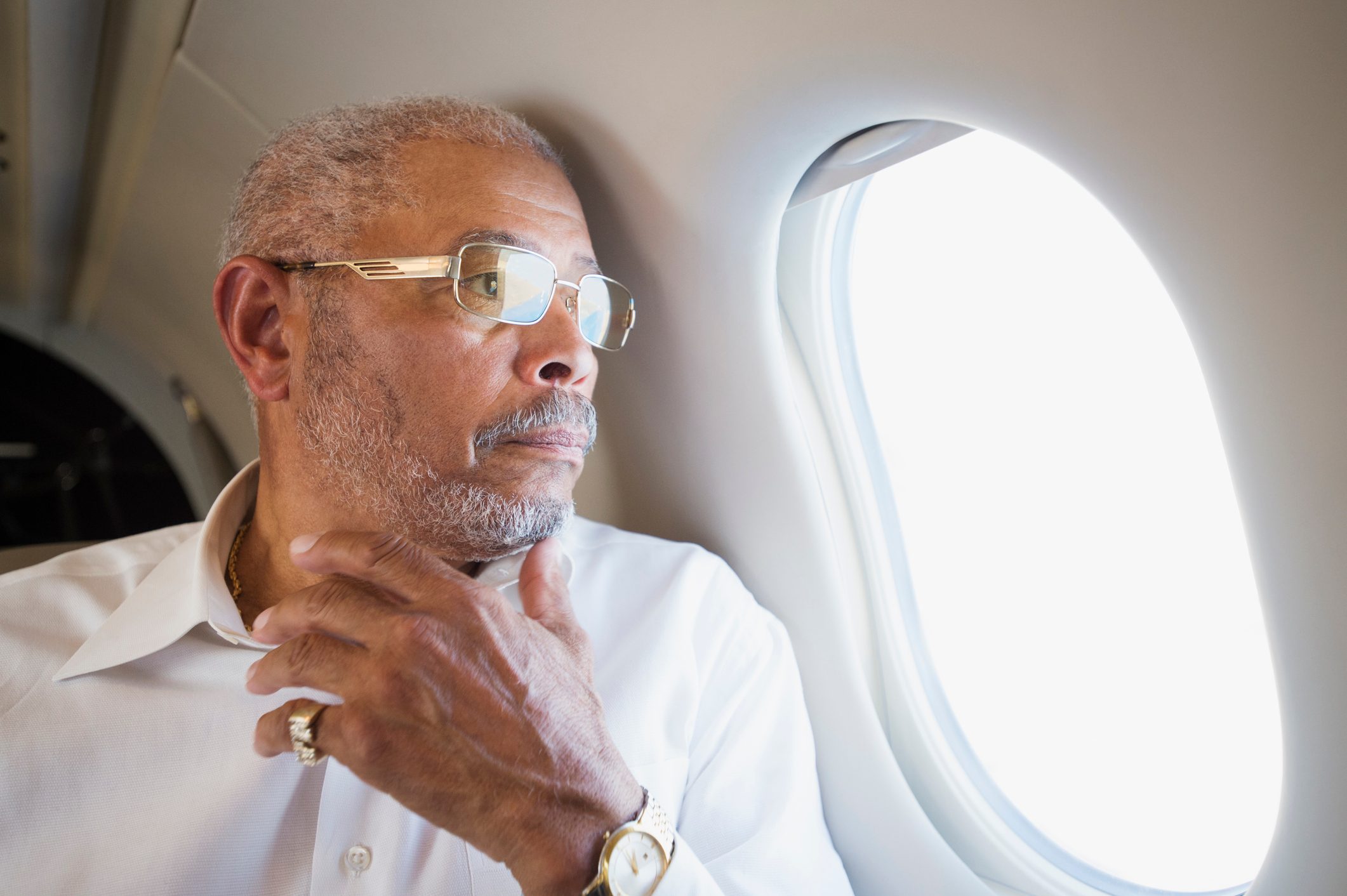 Black businessman looking out airplane window