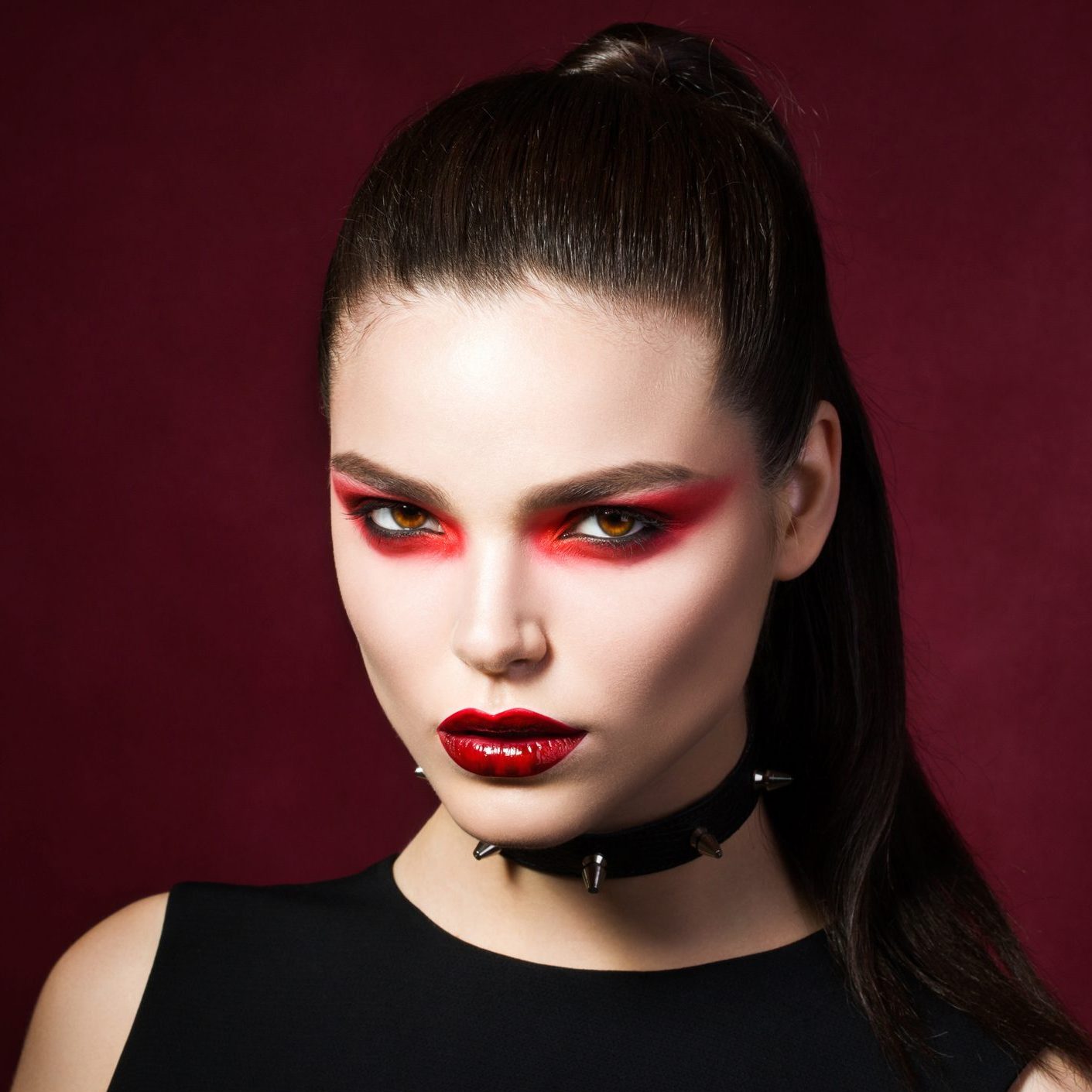 Young beautiful gothic woman with white skin and red lips