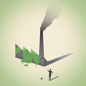 Silhouetted person painting a factory green