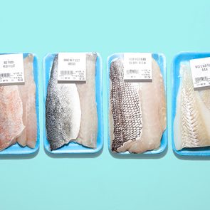 Four fish fillets in packaging on blue background