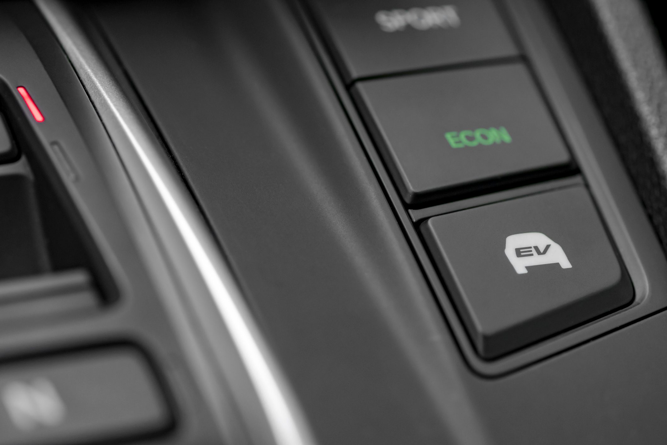 Close up shot of modern hybrid car dashboard selector with fuel efficient and fully electric mode switch buttons