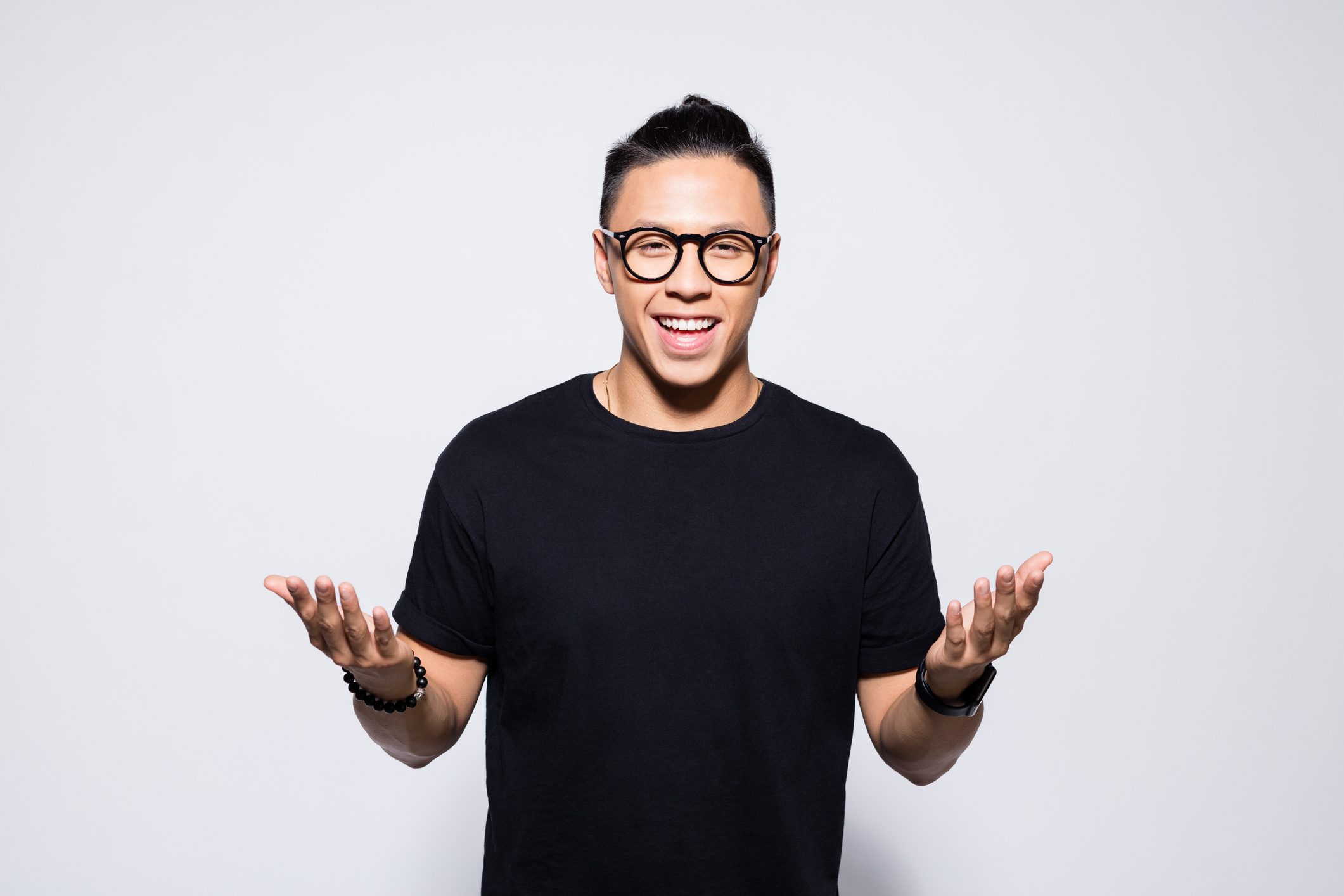 Happy asian young man in black clothes talking with his hands