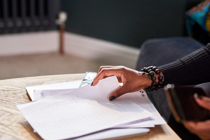 Close up of woman's hands flipping through papers on a table