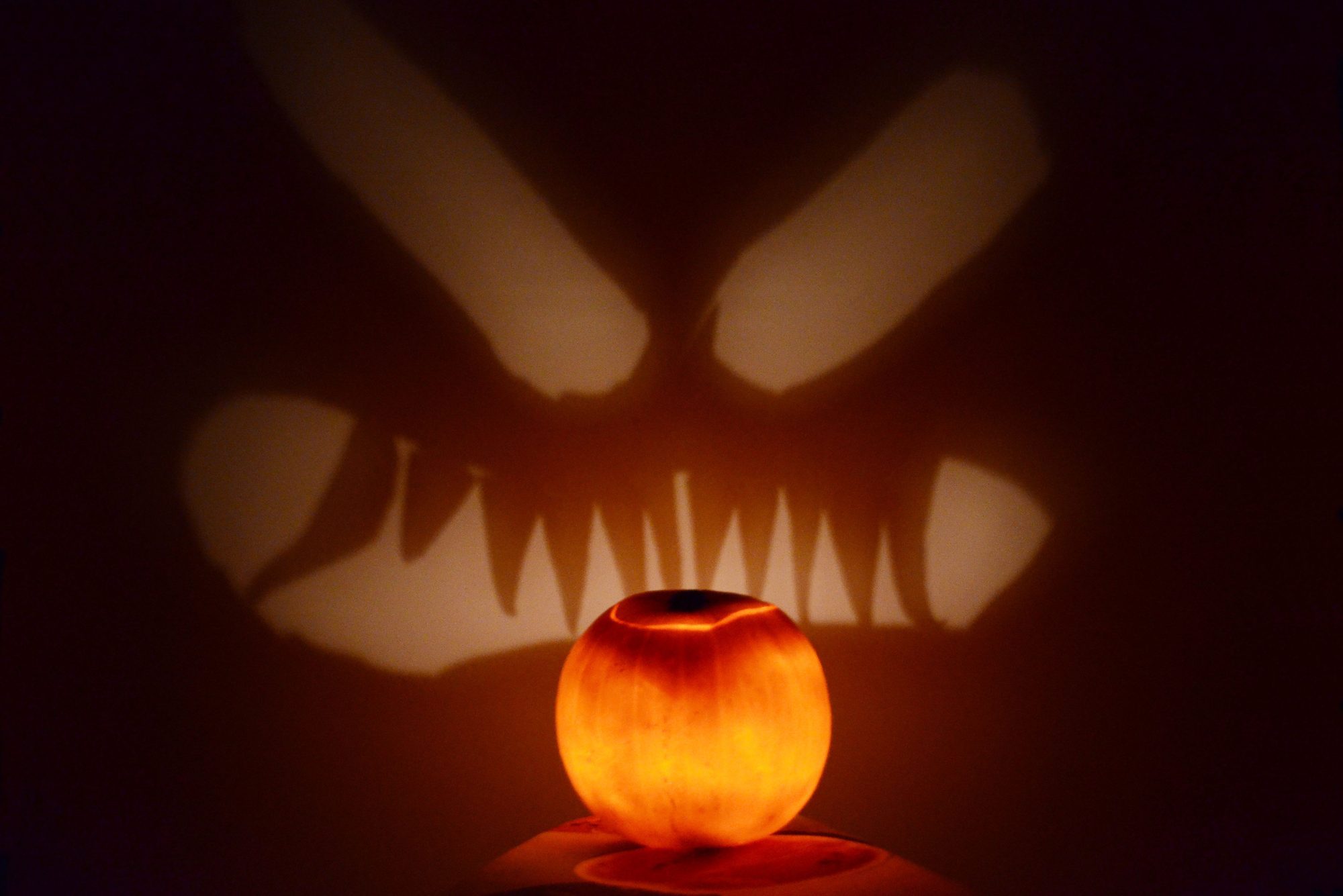 Illuminated Jack-O-Lantern Against Wall