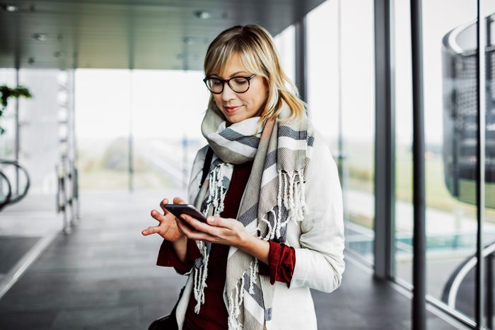 Businesswoman with smart phone standing at the airport