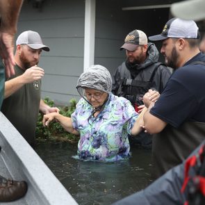 Volunteer rescuer workers help a woman from her home that was inundated with the flooding of Hurricane Harvey on August 30, 2017