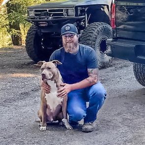 Kaleb Benham poses with his dog, Buddy, who is fully healed from the bear attack