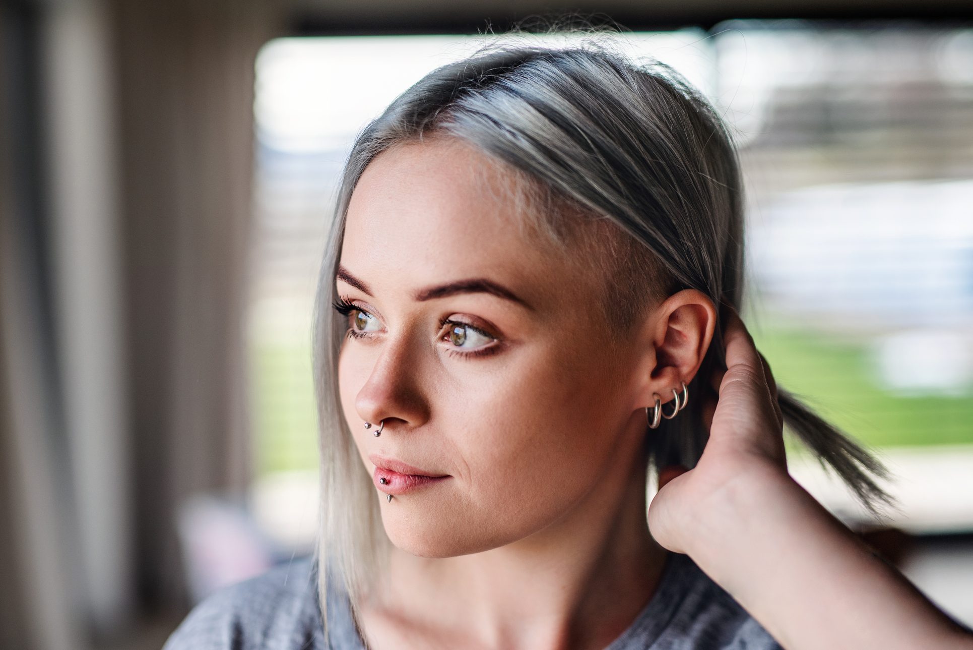 Front view portrait of young woman wearing multiple earrings