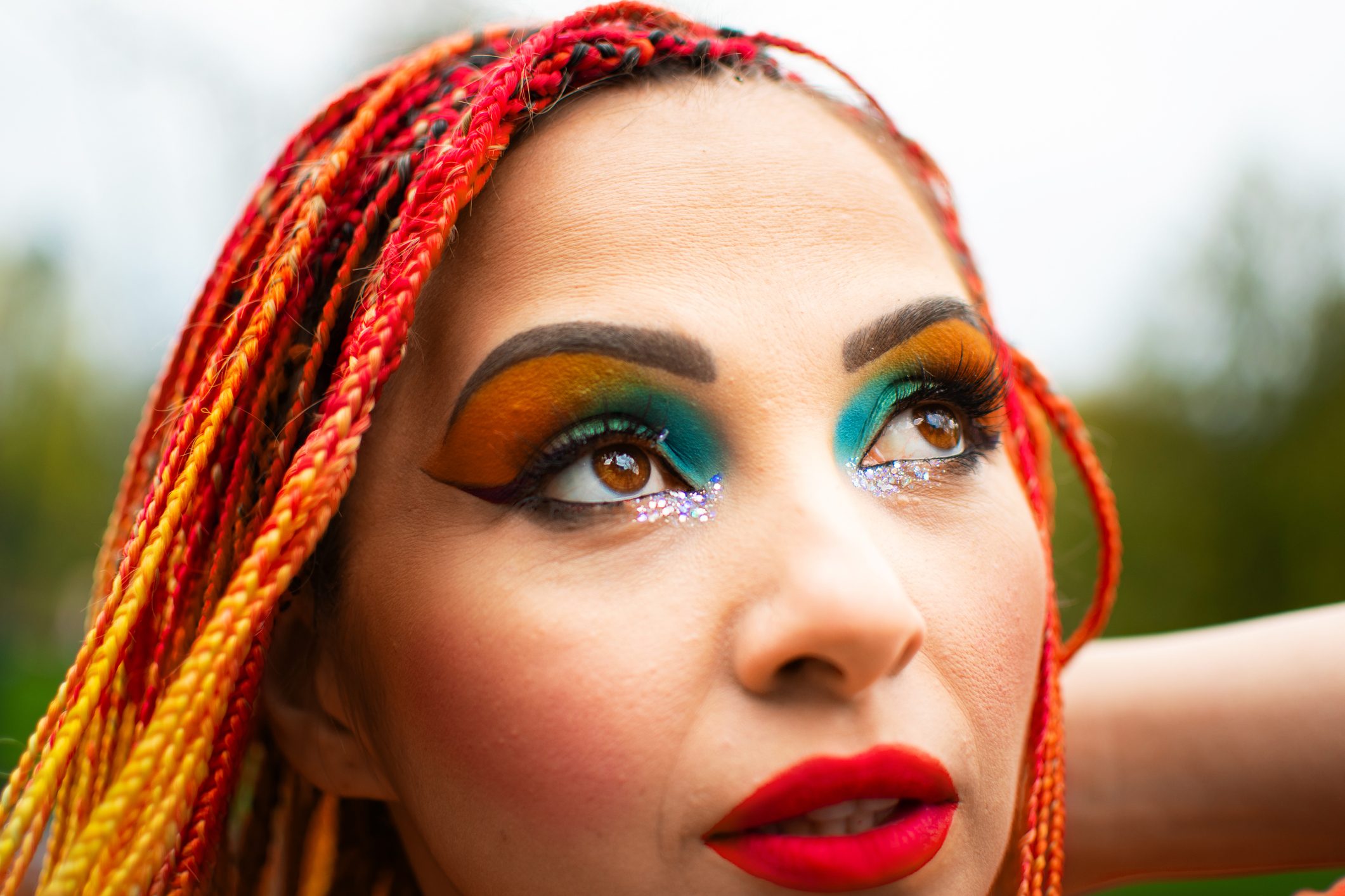 Closeup portrait of beautiful young woman with rainbow dreadlocks