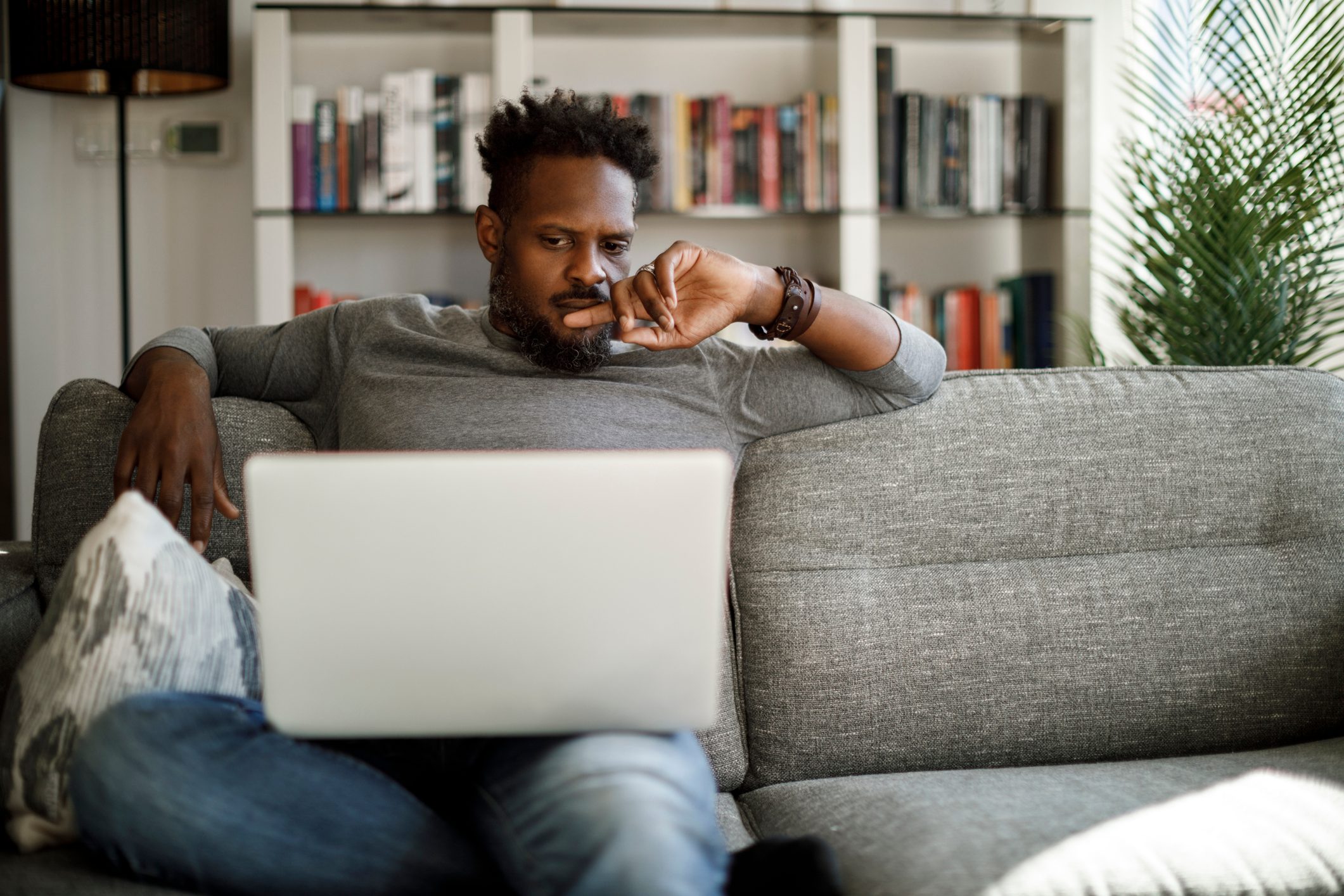 Young man watching movie on laptop at home