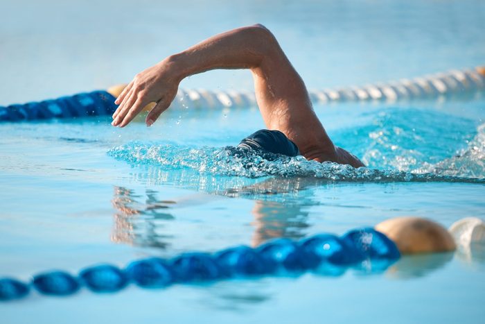 Shot of an unrecognizable young male athlete swimming in an olympic-sized pool