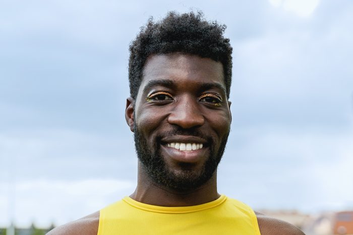 gender fluid African male wearing makeup while looking at camera outdoor - Transgender, queer LGBT concept