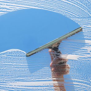 Washing and cleaning a window with a squeegee.