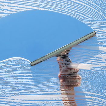 Washing and cleaning a window with a squeegee.