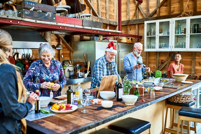 Group of multi racial friends celebrating Christmas in large rustic kitchen
