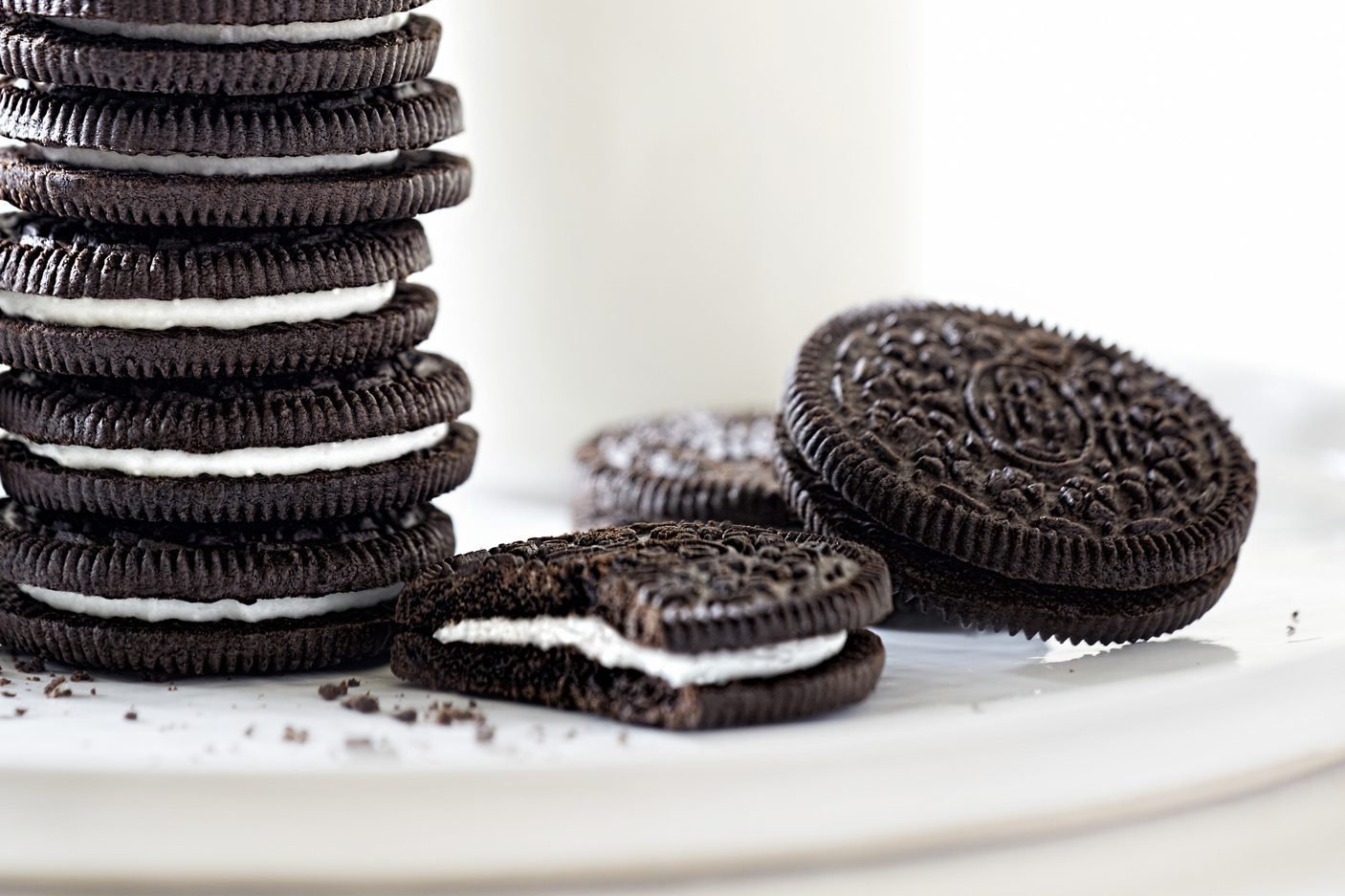 Oreo cookies stacked with milk on white background