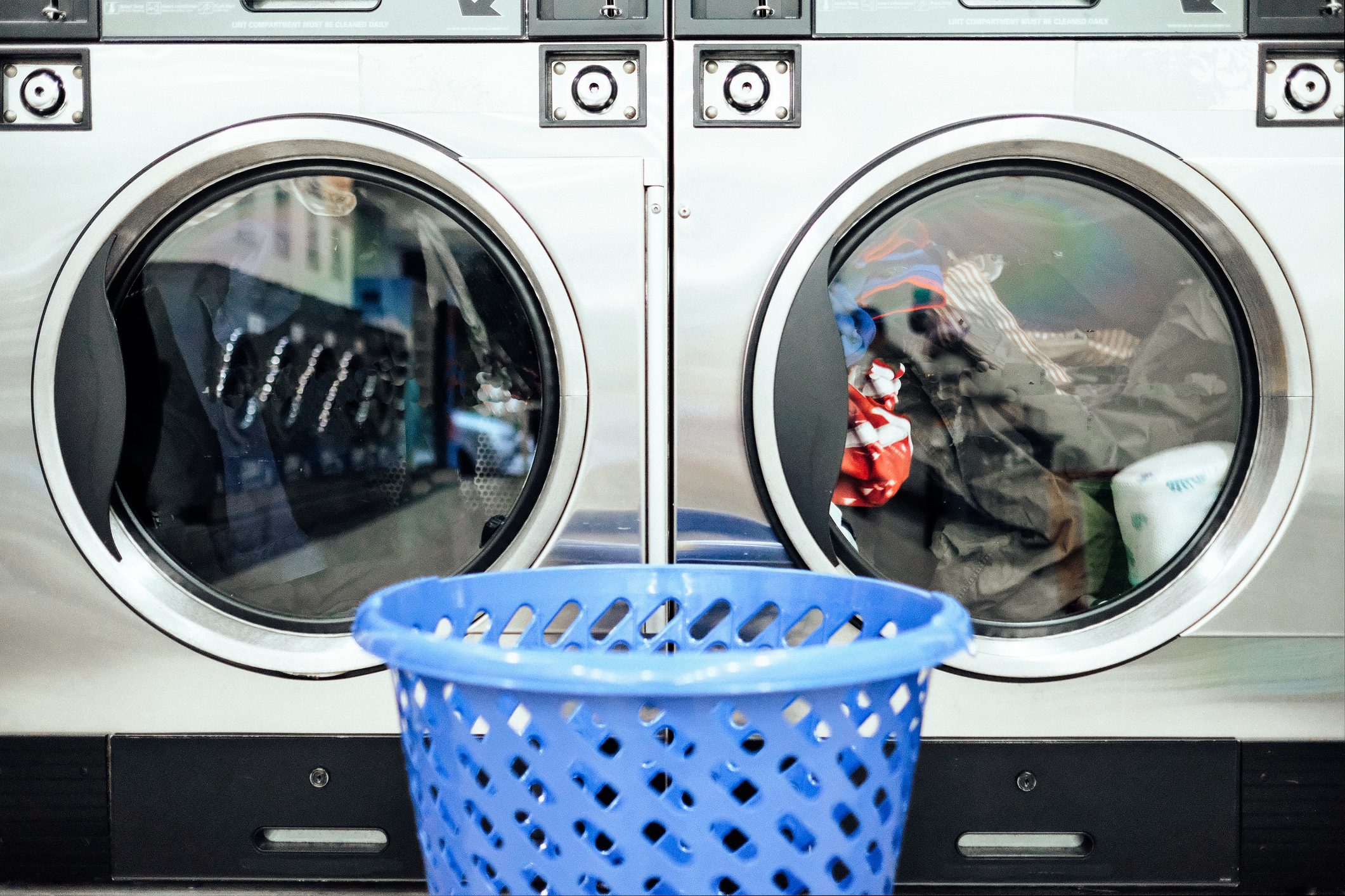 Close-Up Of Basket Against The drying machines at a laundromat