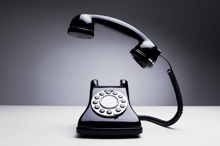 Vintage telephone over dark background with moody lighting