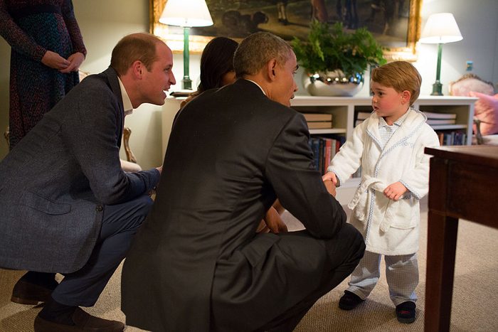 in 2016, Obama bends down to meet Prince George who is wearing a white bathrobe