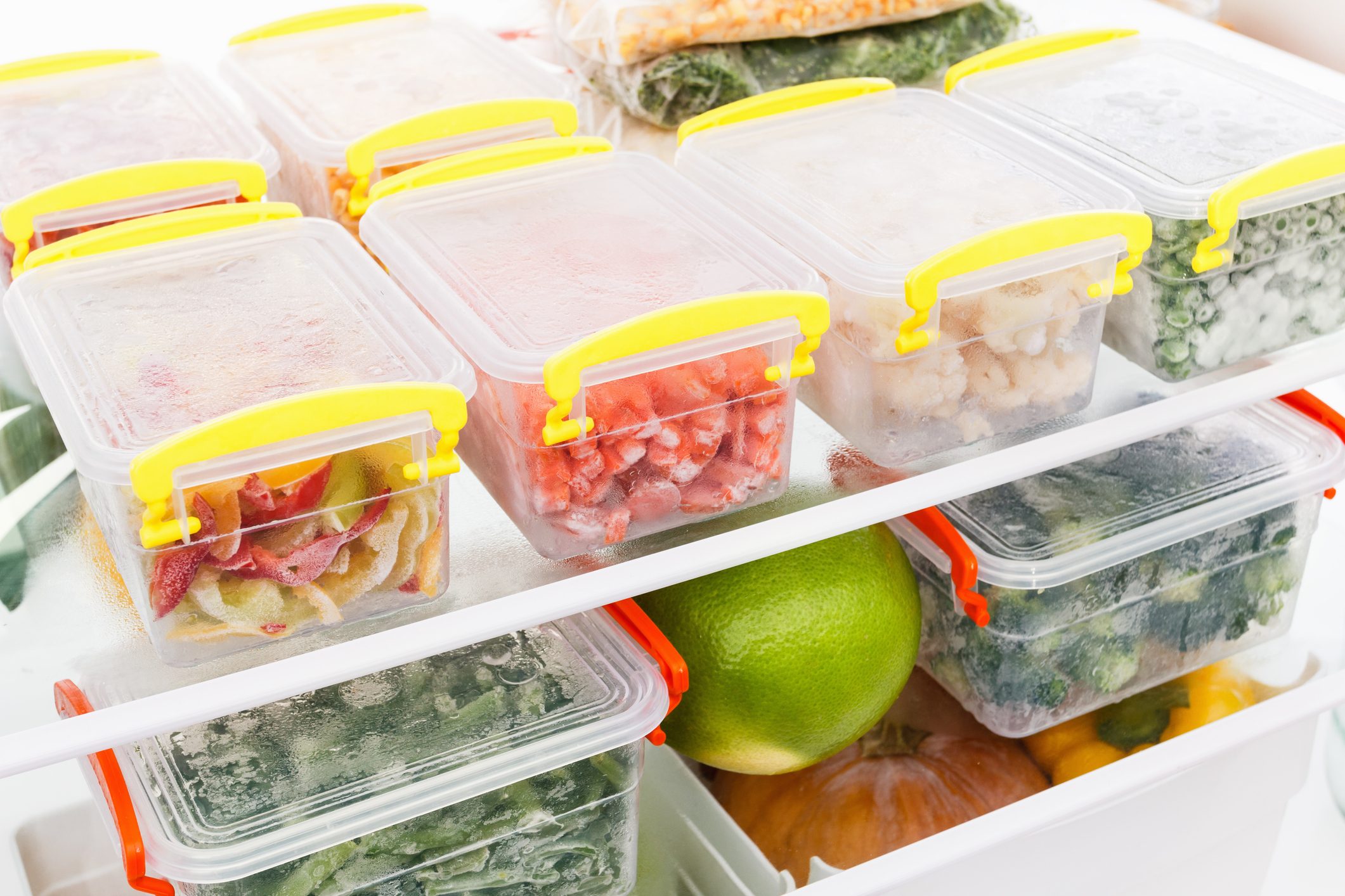 Frozen food in the refrigerator. Vegetables on the freezer shelves.