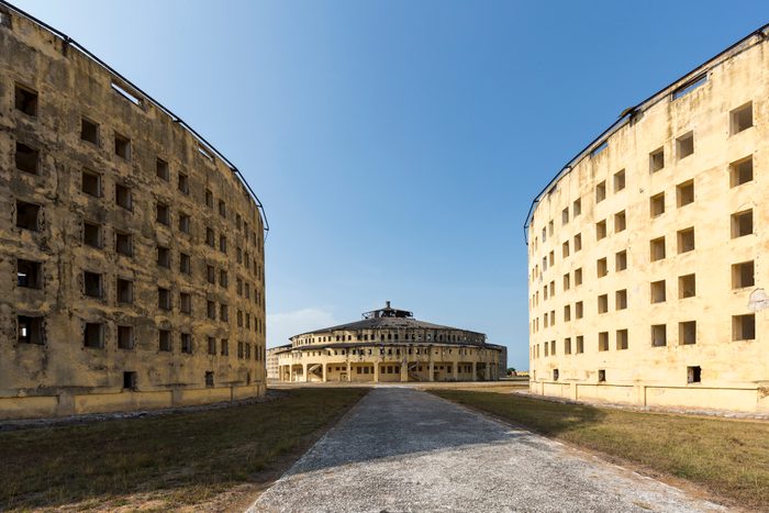 Road leading into the middle of three old building structures making up Presidio Modelo Prison on Isle of Youth, Cuba