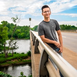 Smiling man leaning on bridge railing