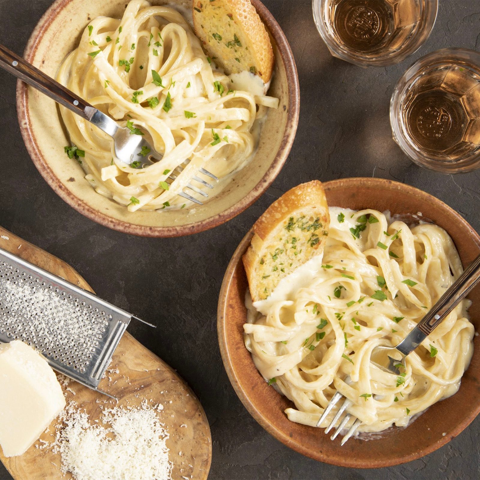 Garlic alfredo sauce with pasta in bowls